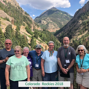 Picture of 7 people traveling together on Colorado tour with tall mountain behind them